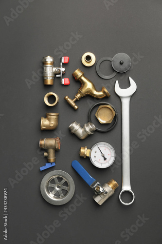 Set of plumber's items on dark background