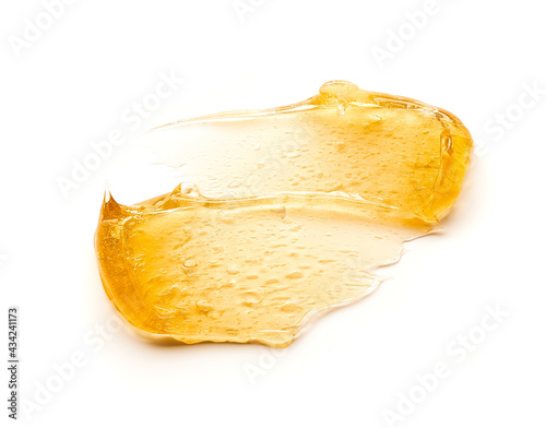 Transparent yellow smear of face cream or golden honey isolated on white background. Golden creamy texture on white background. photo