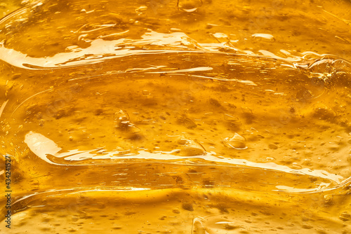 Transparent yellow smear of face cream or golden honey isolated on white background. Golden creamy texture on white background.