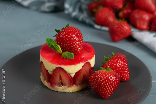 Strawberry dessert on a grey plate and light grey background.