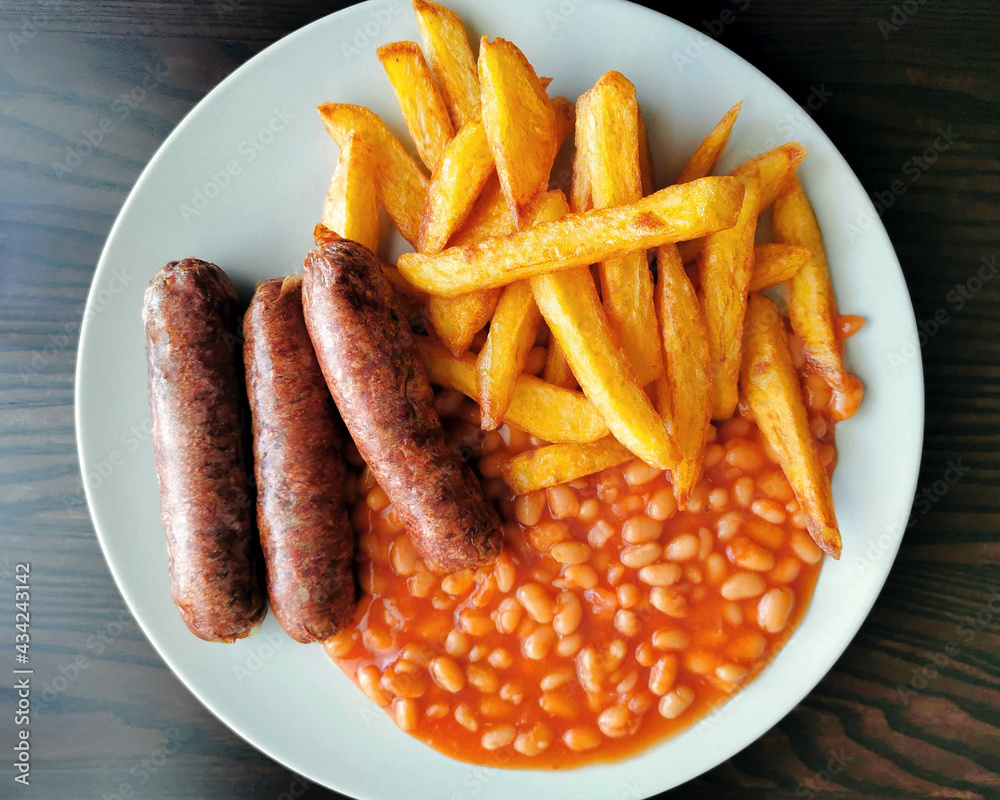 Grilled beef sausages with chips and baked beans. British classic food. Grilled beef sausages with chips and baked beans. British classic food.