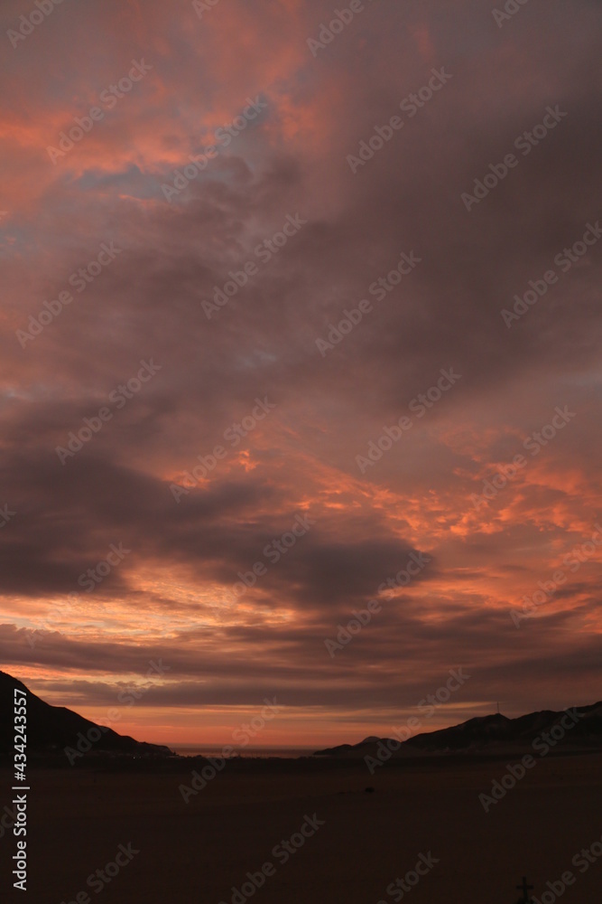 Pink sky clouds sunset with mountain silhouette 