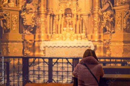 A woman in a temple prays to God. Woman praying in front of altar. Praying woman in front of altar. selected focus