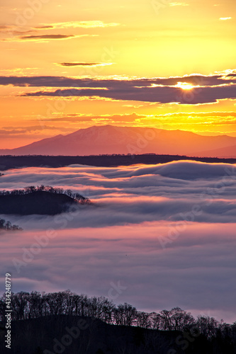Fototapeta Naklejka Na Ścianę i Meble -  輝く朝陽の下に雲海の広がるドラマチックな夜明け。日本の北海道の美幌峠。