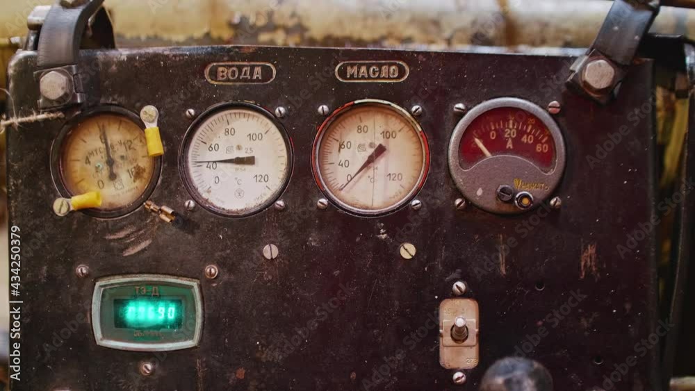 Dashboard of tug with indicators of oil and water temperature of old soviet tank engine.. Writing in Russian watter and oil