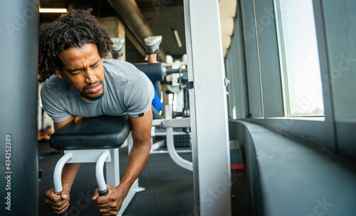 Young handsome man doing exercises in gym