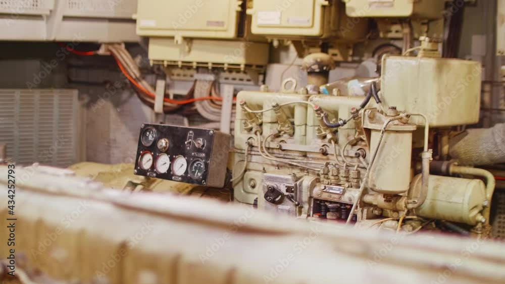 Diesel generator and black dashboard in engine room of old tug.
