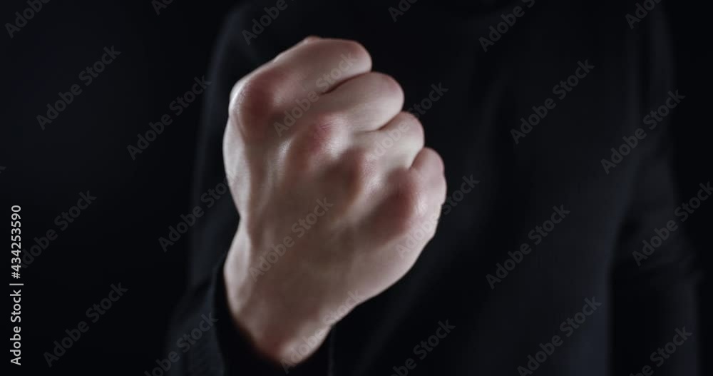 Angry man threatens with index finger and threatens with his fist. Dangerous man demands submission and threatens with violence on black background. Terrible boss requires monitoring and subordinated Angry man threatens with index finger and threatens with his fist. Dangerous man demands submission and threatens with violence on black background. Terrible boss requires monitoring and subordinated