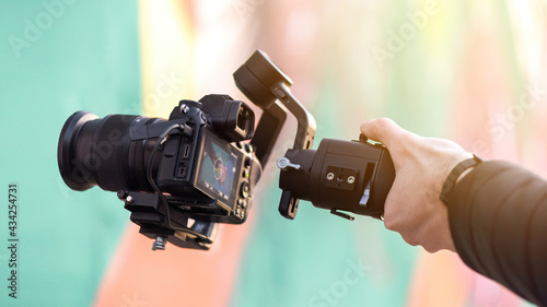 Male hand holding a camera on steadycam photo