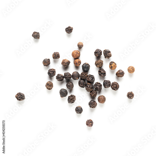 black peppercorns scattered on a white background
