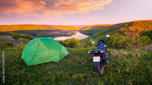 Motorcycle traveling concept, camping with a tent, scenic nature landscape with canyon in the national nature park Podilski Tovtry, Studenytsia and Dnister river, Ukraine