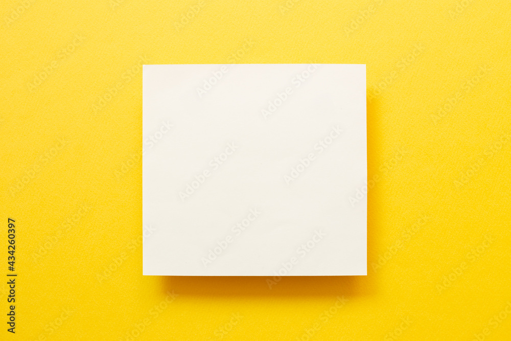 White memo pad on yellow background. top view, copy space White memo pad on yellow background. top view, copy space