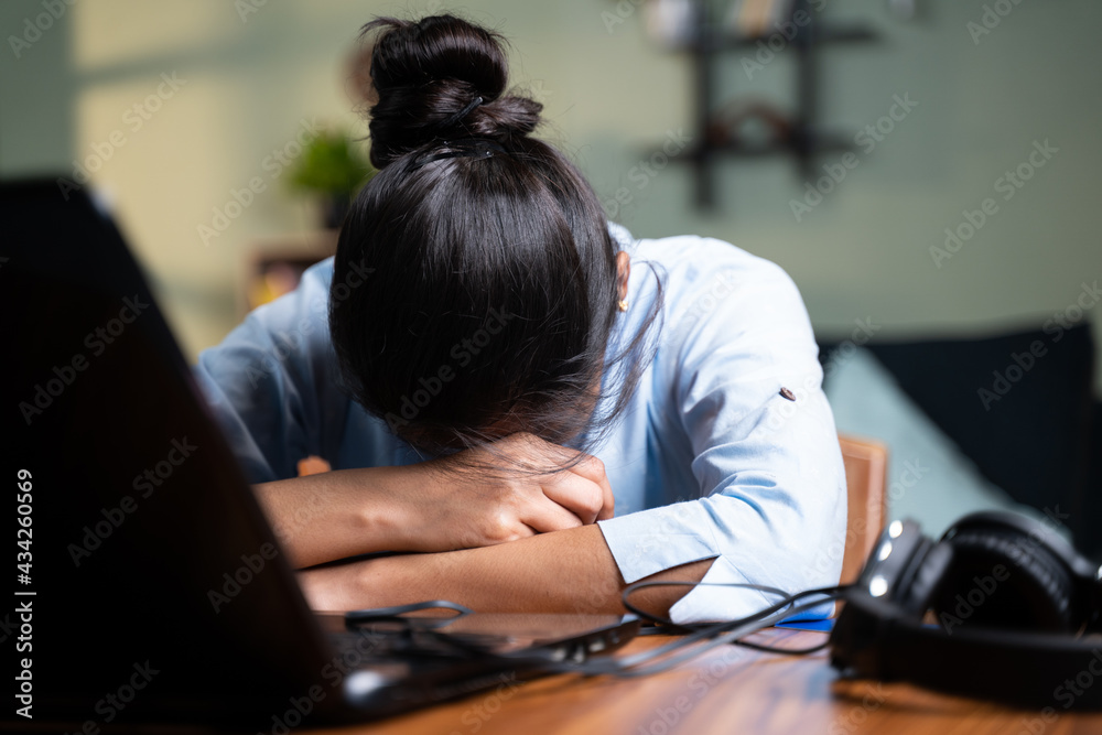 young Business woman sleeping by closing laptop while working, concept of new normal burnout, over or late night work at home during coronavirus covid-19 pandemic