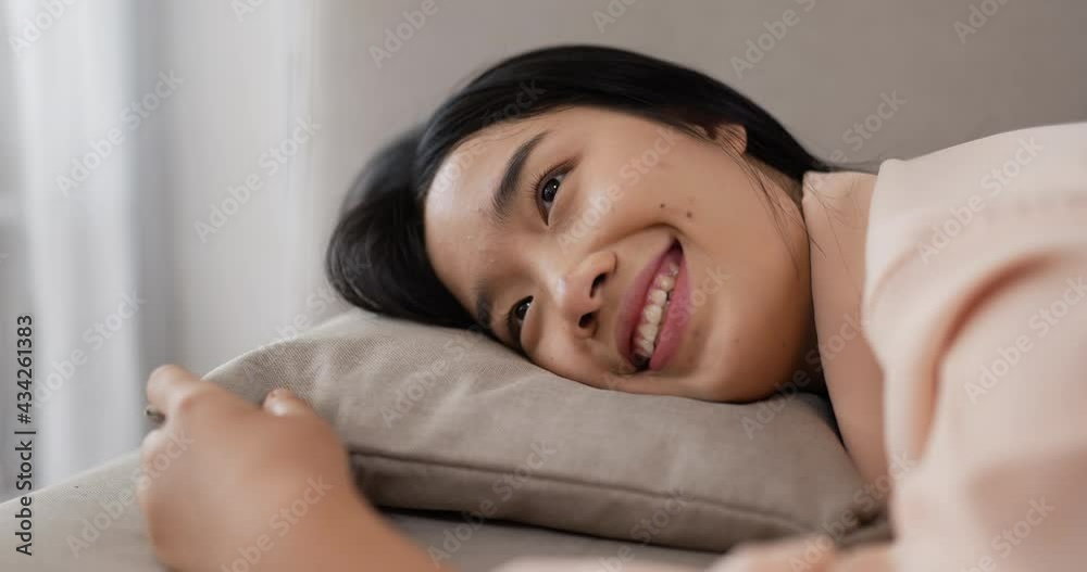Thai woman laying on sofa.