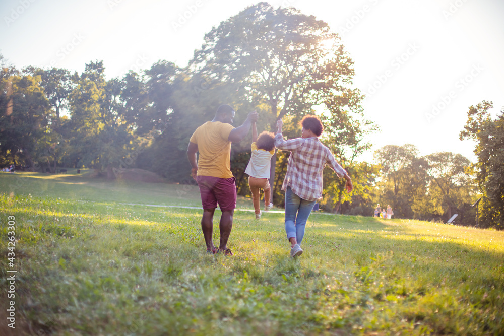 Fototapeta premium African American family having fun outdoors. Playful family.
