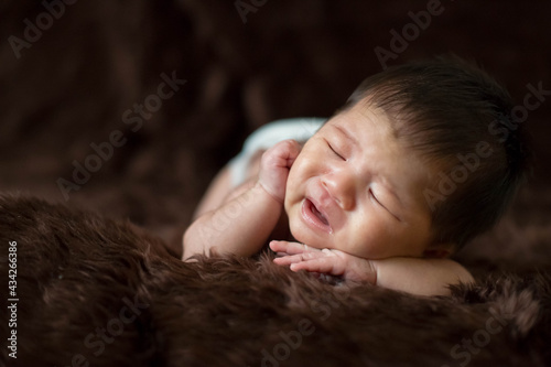 Cute Asian newborn baby on brown fur blanket background.
Nice portrait of little child boy.