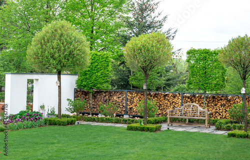 Piękny nowoczesny ogród z ławeczką. Ściana w ogrodzie ciekawy detal architektury ogrodowej