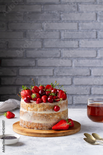 Summer cake with berries on a gray table in the kitchen