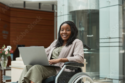 Print op canvas Portrait of African disabled woman smiling at camera while sitting in wheelchair