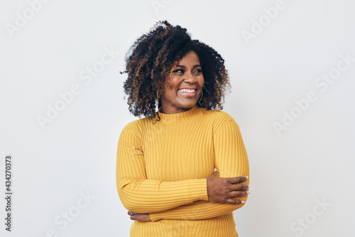 Leinwand Poster Portrait of smiling beautiful black woman standing against white background with