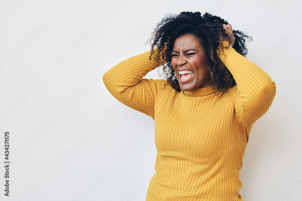Woman screaming with both hands on head, headache Woman screaming with both hands on head, headache
