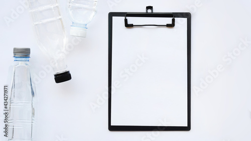 close up of empty paper and bottle of water isolated on white background                          