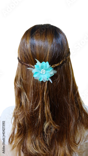 Back view shot of a young woman with long brunette hair with curly end, in white dress with a light blue flower hair ornament.