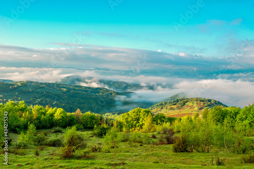 countryside in the mountains in the fog at sunrise. Beautiful Landscape.