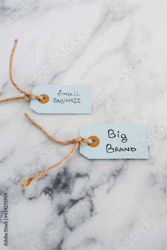 product tags with small business vs big brand texts with focus on the big one, concept of customer behaviour