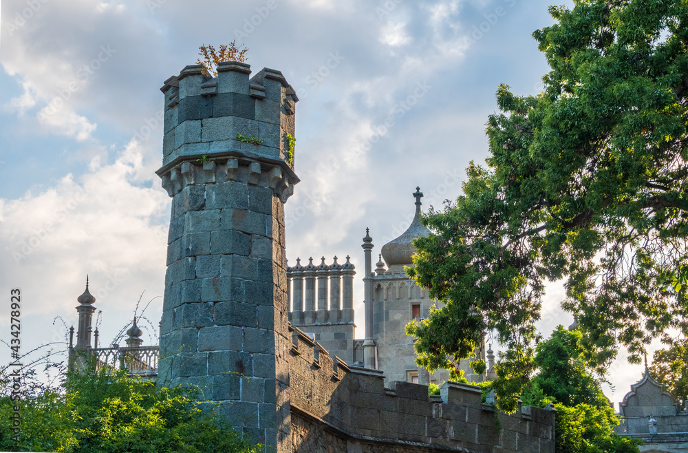 Fototapeta premium The walls and towers of the old palace on the background of a blue sky at sunset