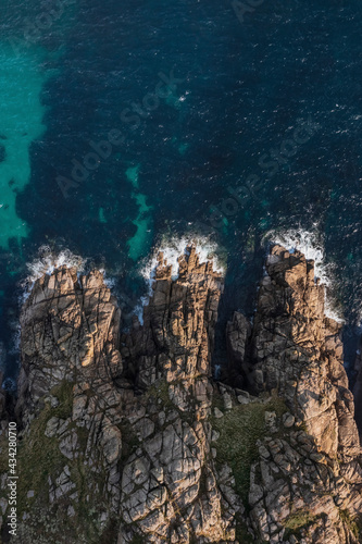 Aerial view of waves breaking along the wild coastline in St. Levan, Penzance, Cornwall, United Kingdom. photo