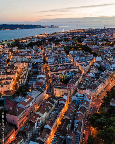 Aerial view of Alcantara residential district of Lisbon with Tagus river in background at sunset, view of city skyline illuminated, Lisbon, Portugal. photo