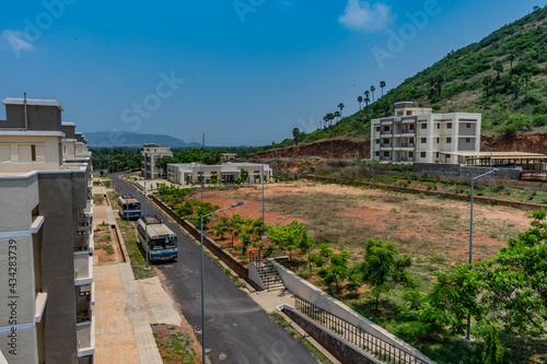 Top view of an Indian colony with bitumen road inside parking a bus, Building looking in line with pattern.