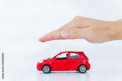 A Man with protective gesture small red car with man hand. Car (automobile) insurance and collision damage waiver concepts.