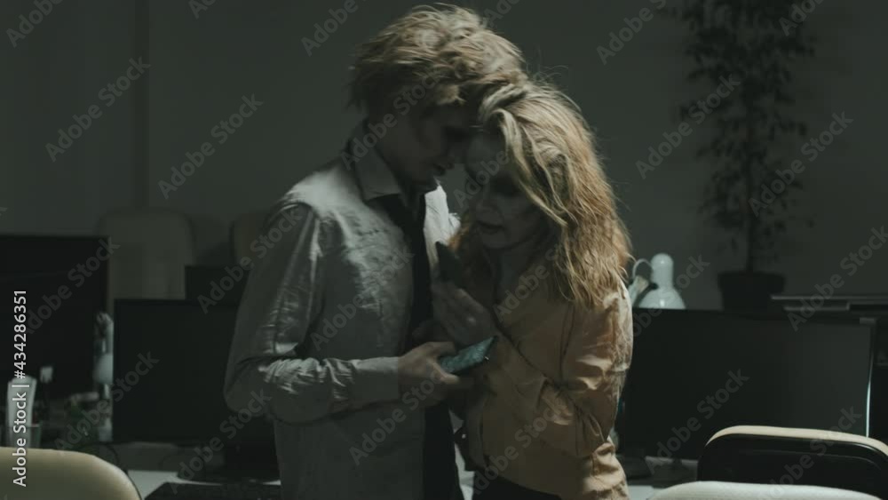 Tracking shot with slowmo of zombie woman and man looking at their ...