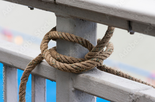 The photo shows a twisted rope on a metal railing