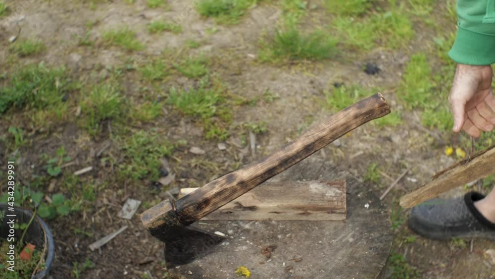 Slow movement thrusting the axe into the stump and removing the hand from the handle Slow movement thrusting the axe into the stump and removing the hand from the handle