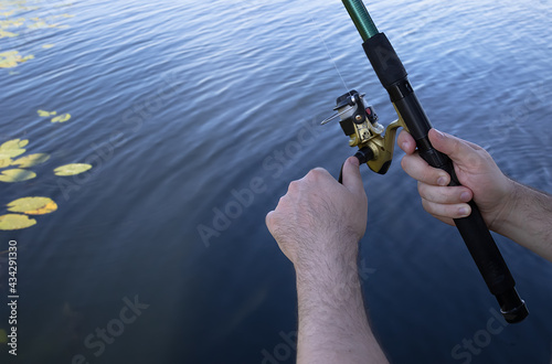 man holding fish bait and fishing rod in his hands.Hobby and leisure concept.