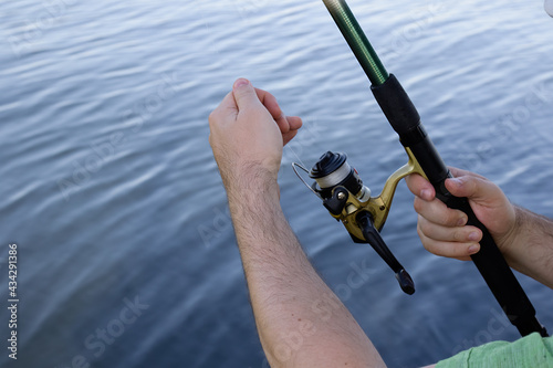 man holding fish bait and fishing rod in his hands.Hobby and leisure concept.