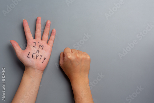 the text I am a lefty written in the palm of a left-handed woman