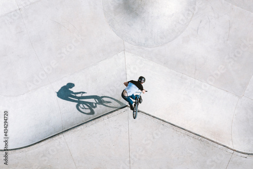 Aerial view of BMX bike rider doing turn down trick in local skatepark in Panevezys, Lithuania. photo