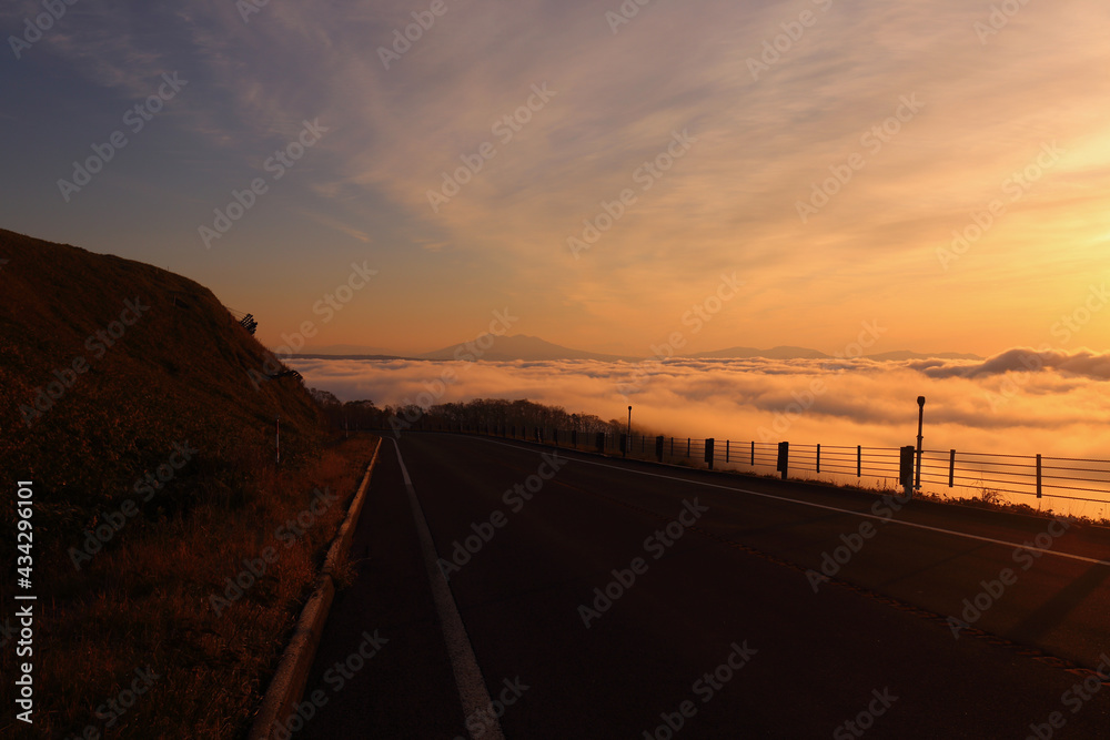 雲の上を走る峠道とその先に見える藻琴山