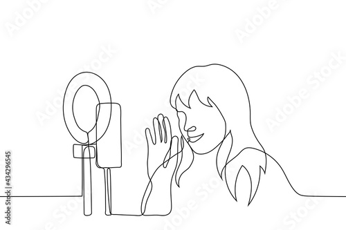 female blogger smiling at the camera of smartphone and waving to viewers during a live - one line drawing. concept of live stream, live broadcast,  online fan meeting with a star (idol)