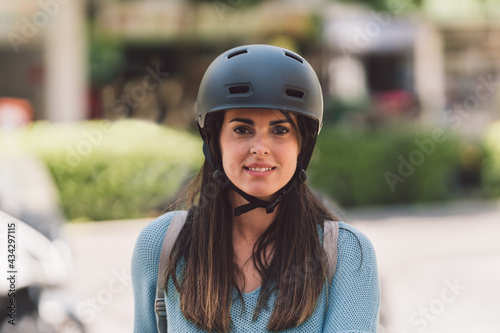 Portrait of a young woman wearing a bicycle helmet outdoors © Samuel Perales