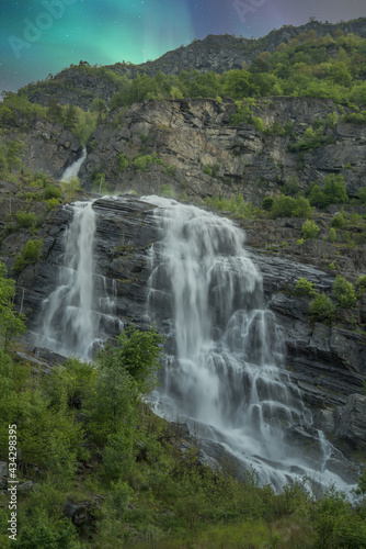 beautiful waterfalls with crystal clear water with mountains in the background at sunset Norway.