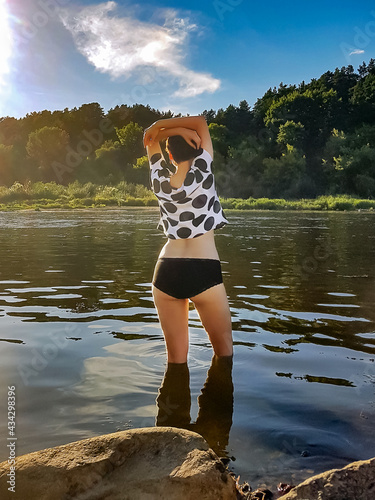 A girl in a swimsuit. The girl in the river