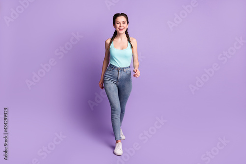 Full length body size view of attractive cheerful content girl walking isolated over violet purple color background