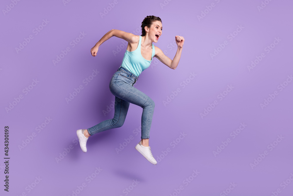 Full length body size profile side view of attractive cheerful girl jumping running isolated over violet purple color background
