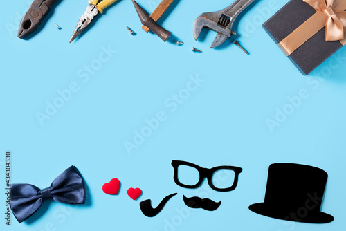 Father's day background design concept. Top view of paper decoration and working tools on blue table background.