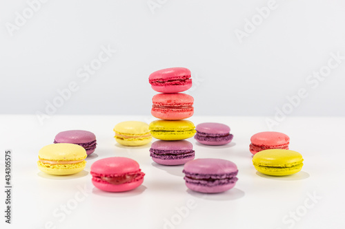 colorful macaroni cakes stacked in a tower and a circle on a white background